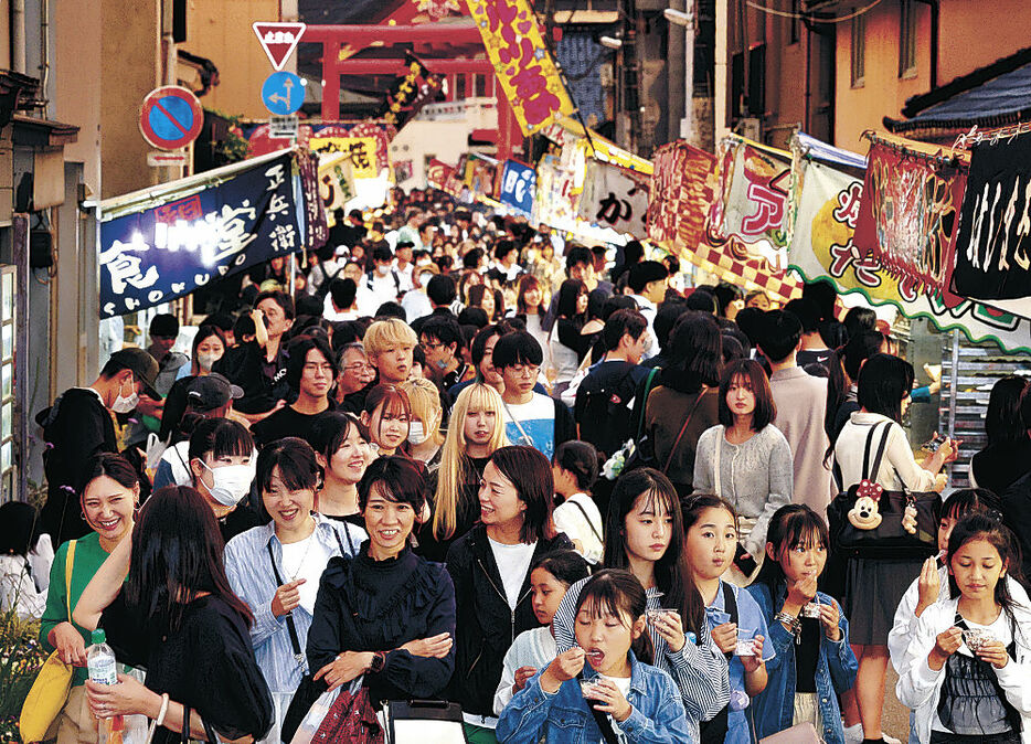 露店が並ぶ通りで祭りを満喫する大勢の人＝３１日午後７時、富山市西町
