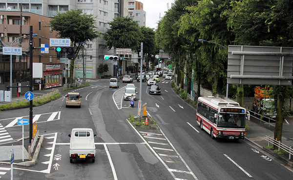 甲州街道の仙川三差路を通過する、よみうりランドからの折り返しの新宿駅西口行き。画面左端の道は旧甲州街道で、よみうりランド行きはこちらを走行（水野二千翔撮影）。