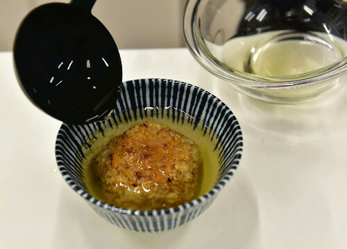 こんがり焼いたおむすびを器に入れ、湯でお好みの塩加減に薄めた白だしを注ぎ入れる