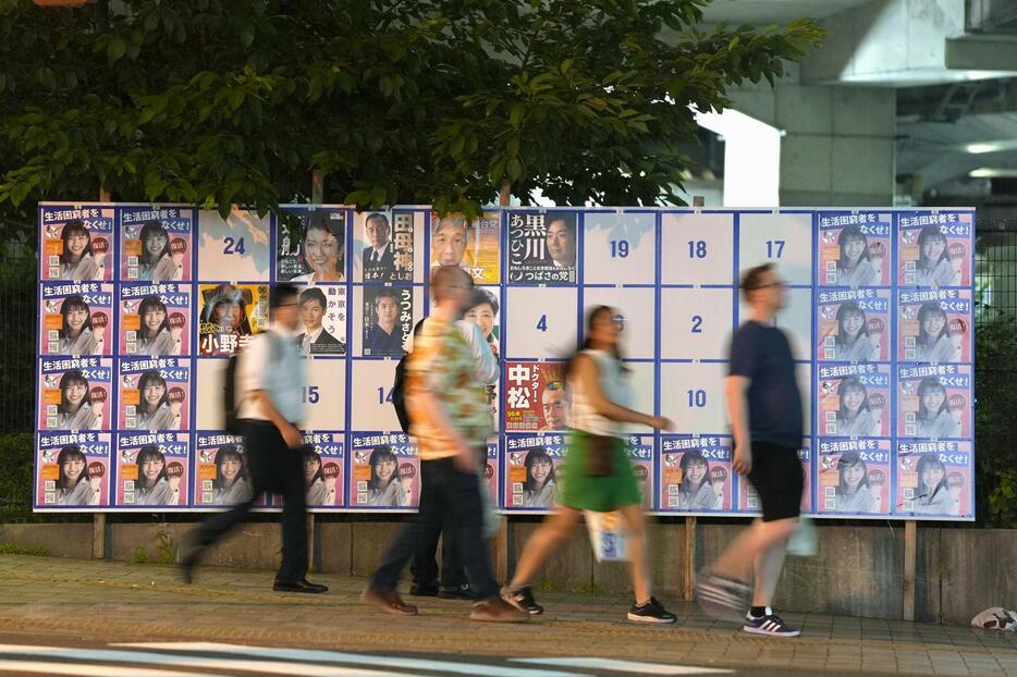 東京都知事選で、同一のポスター（左右と下）が張られた掲示板＝20日、東京都台東区
