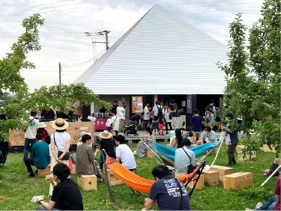 白い三角屋根が特徴的な弘前シードル工房kimoriの前にあるリンゴ園地で開かれる。写真は昨年の様子