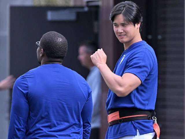 トレーニング中、スミスコーチに筋肉ポーズを決める（？）大谷翔平 photograph by JIJI PRESS
