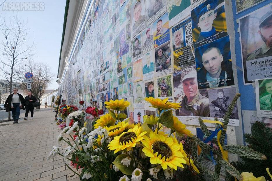 キーウの聖ミハイ修道院前の壁には、2014年から現在までの戦没兵士の写真が並ぶ。 戦死者はいまも増え続けている。同時にまた、ロシア軍の側にも、多数の犠牲が出ている。(2024年3月・キーウ・撮影：玉本英子）