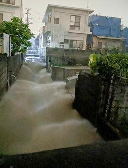 大雨で水路から水が吹き出した様子＝１４日、那覇市首里石嶺町