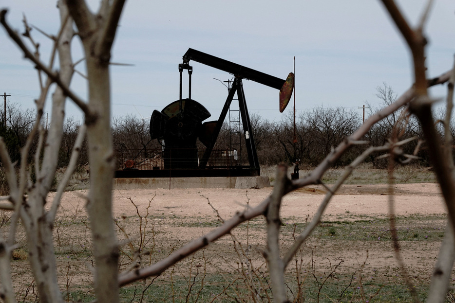 　６月１１日、米エネルギー情報局（ＥＩＡ）が発表した６月の短期エネルギー見通しで、２０２４年の米原油生産予想を前年比３１万バレル増の日量１３２４万バレルとし、過去最高予想だった５月からさらに４万バレル上方修正した。写真は、米テキサス州西部パーミアン盆地のイエーツ油田で原油を掘削するポンプジャック。２０２３年３月撮影（２０２４年　ロイター/Bing Guan）