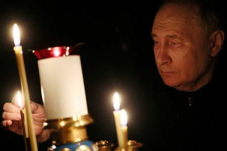 　6月２５日、   ロシアのプーチン大統領は、ウクライナで続く戦争が西側諸国との間で繰り広げられている存亡を賭けた闘争の一環であり、全ての国力を集中させる必要があると訴えている。写真は３月、モスクワ近郊のコンサートホールで起きた銃乱射の犠牲者を悼む式典で、ろうそくに火を灯すプーチン氏（２０２４年　ロイター/Sputnik/Mikhail Metzel）