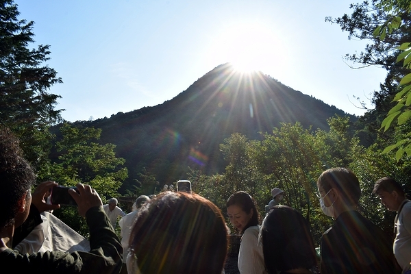 スマホなどで沈む太陽を写す人たち