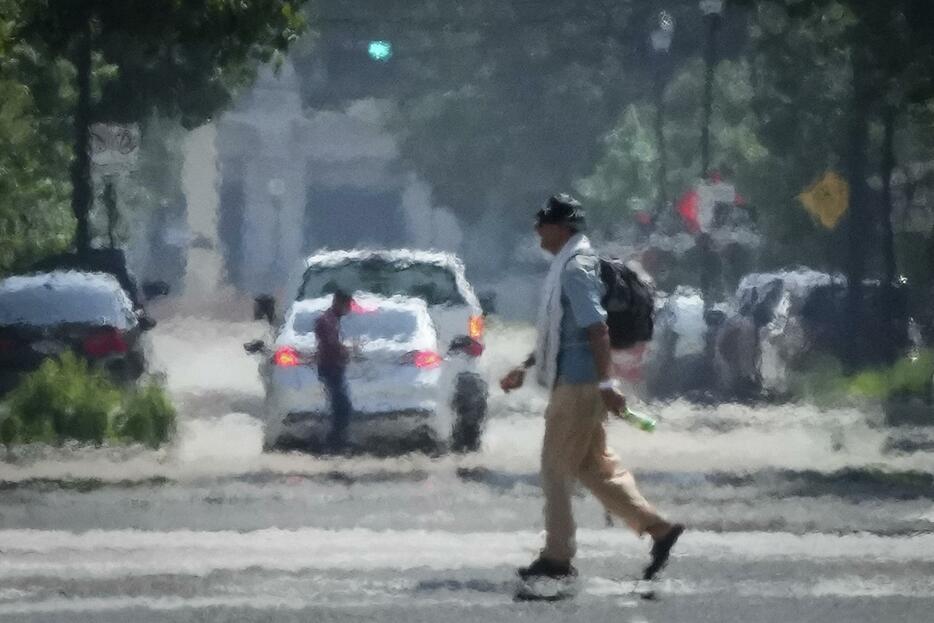 猛暑の日に、米南部テキサス州の道を横断する男性＝5月25日（Jon　Shapley/ヒューストン・クロニクル提供・AP＝共同）