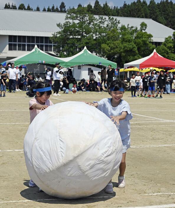 石川県珠洲市の総合公園で運動会が開かれ、大玉転がしをする子どもたち＝1日午前
