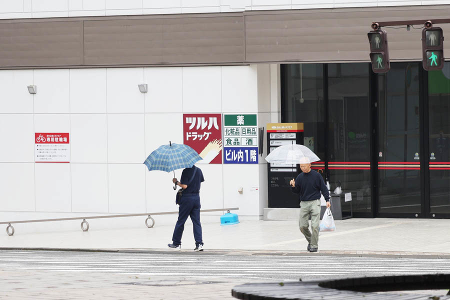 傘を差して歩く人たち（21日正午ごろ、飯田市街地）