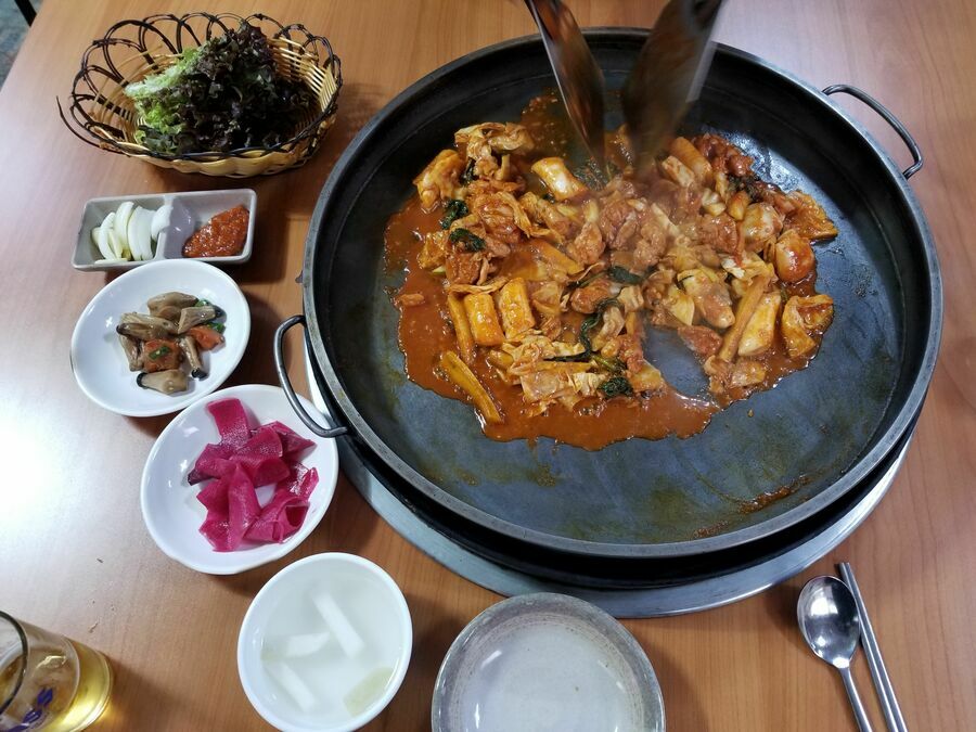 江原特別自治道・春川の名物料理のタッカルビは、鶏肉と、キャベツやさつまいもなどの野菜を、ヤンニョム（薬味だれ）で炒めた料理