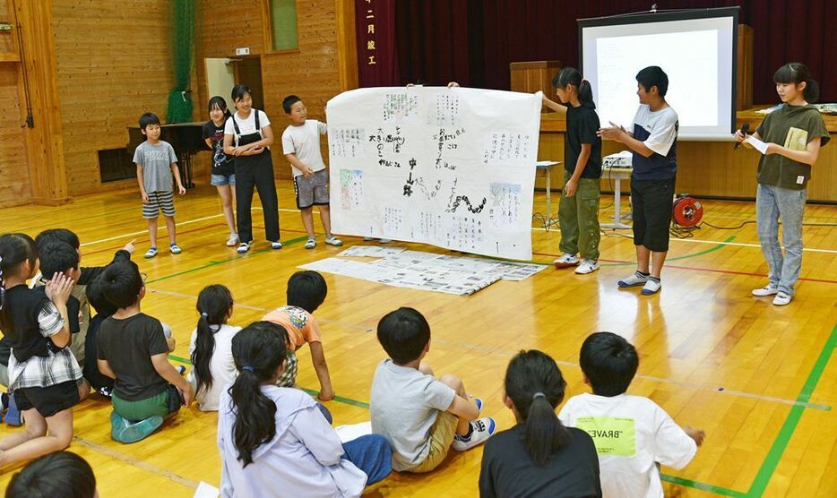 その場で仕上げた「文字アート」を披露する言葉チームの児童（和歌山県田辺市龍神村柳瀬で）