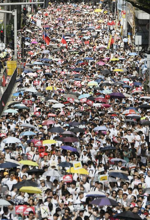 「逃亡犯条例」改正案に反対し、香港中心部をデモ行進する参加者ら＝2019年6月9日、香港（共同）