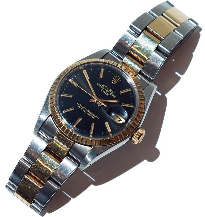 「ロレックス」の腕時計。1977年のオイスターパーペチュアルはブラック文字盤に、ゴールド×シルバーカラーのミックスが映える。