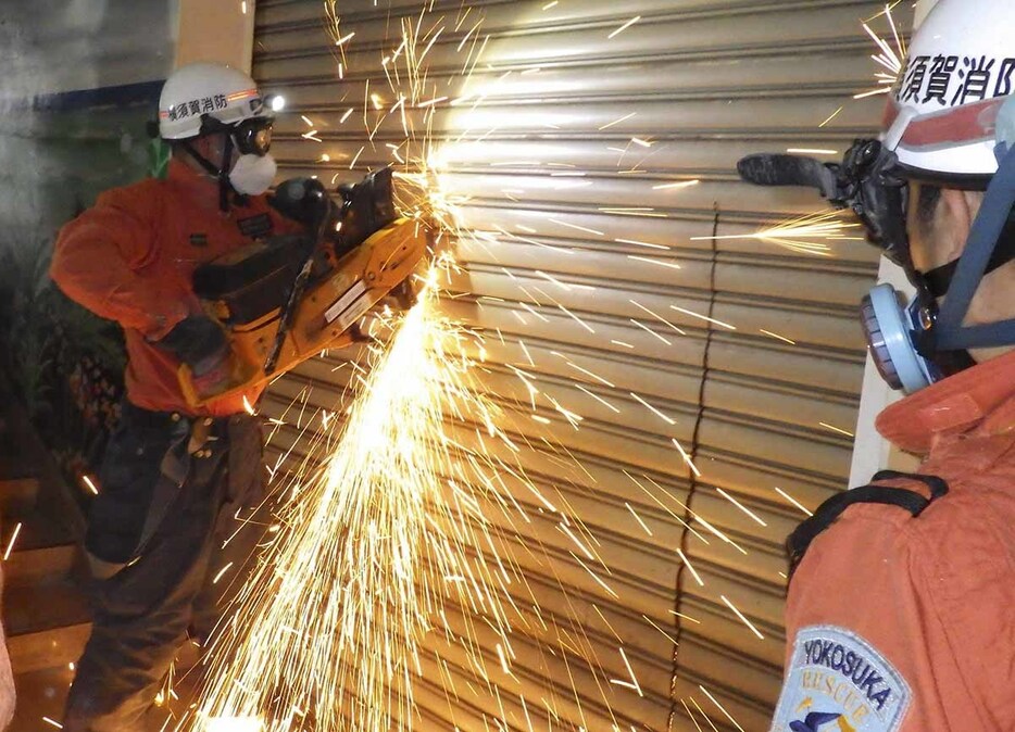 解体中ビル内でエンジンカッターでシャッターを壊す訓練をする横須賀市消防局の署員（同局提供）