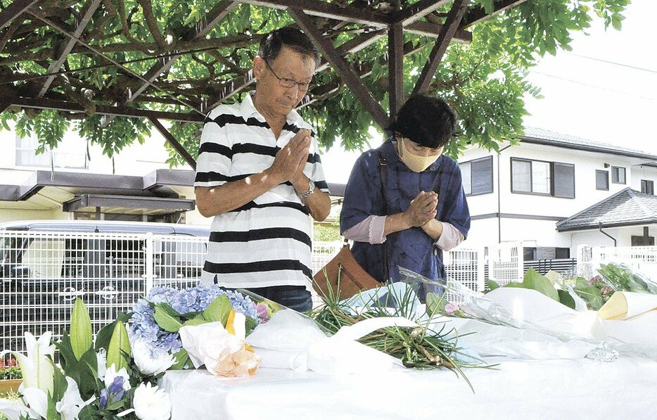 田町児童遊園に設けられた献花台で手を合わせる夫婦