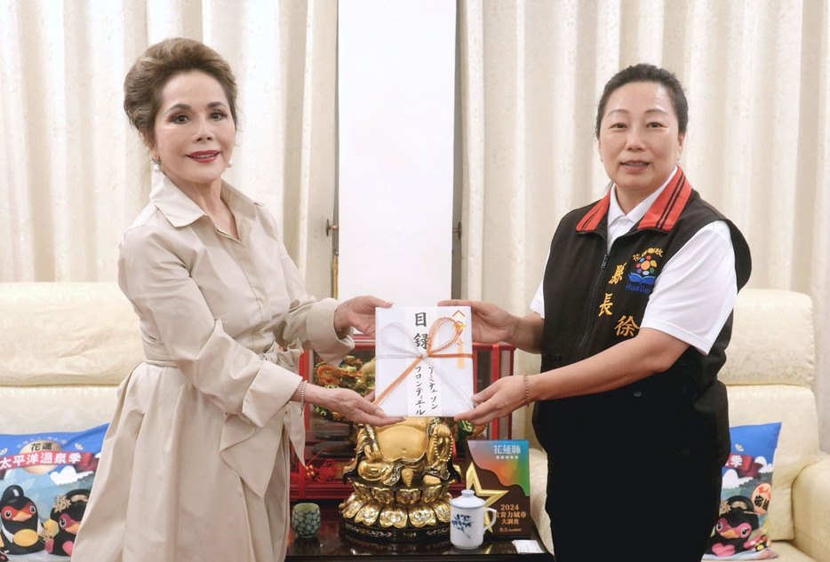 29日、台湾東部・花蓮県で徐榛蔚県長（右）に寄付金の目録を渡すデヴィ夫人（共同）