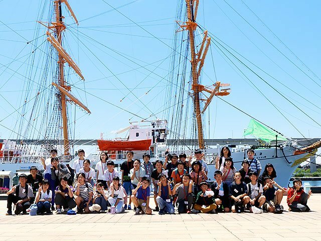 帆船「海王丸」の前で記念撮影をする児童たち