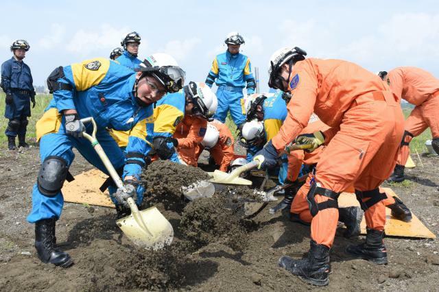 救助のため土を掘り進める隊員ら＝１１日午前、宮崎市・宮崎港