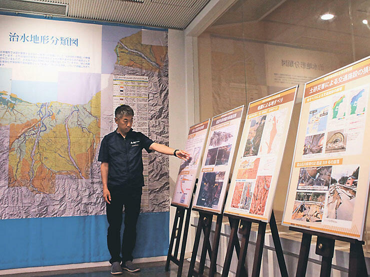 地震による土砂災害をテーマにしたパネル（右）と液状化リスクの高い場所を示す巨大地図（奥）=立山カルデラ砂防博物館