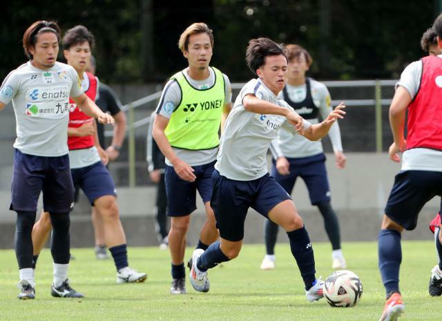 テゲバジャーロ宮崎の練習で積極的にボールに触れる日章学園高の高岡伶颯選手（中央）＝４日午後、宮崎市・ひなた県総合運動公園ラグビー場