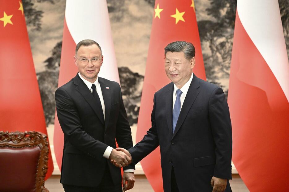握手を交わすポーランドのドゥダ大統領（左）と中国の習近平国家主席＝24日、北京の人民大会堂（共同）