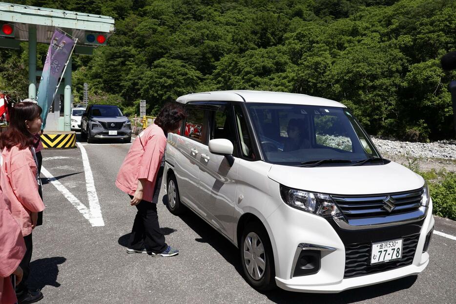 全線開通したホワイトロードの料金所を通過した車＝14日午前、石川県白山市