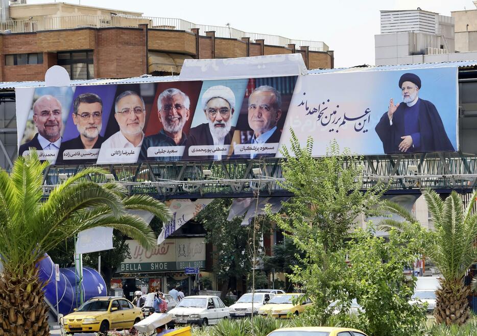 イランの首都テヘランに設置された故ライシ大統領（右端）と大統領選候補者の看板。撤退候補も含まれている＝26日（共同）