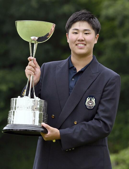 第108回日本アマチュアゴルフ選手権で史上最年少優勝を果たし、カップを手に笑顔の松山茉生＝28日、兵庫県広野GC