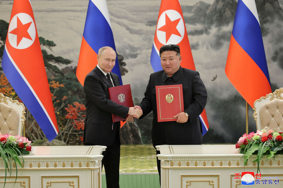 握手するロシアのプーチン大統領（左）と北朝鮮の金正恩朝鮮労働党総書記＝１９日、平壌（朝鮮中央通信提供）（ＡＦＰ時事）