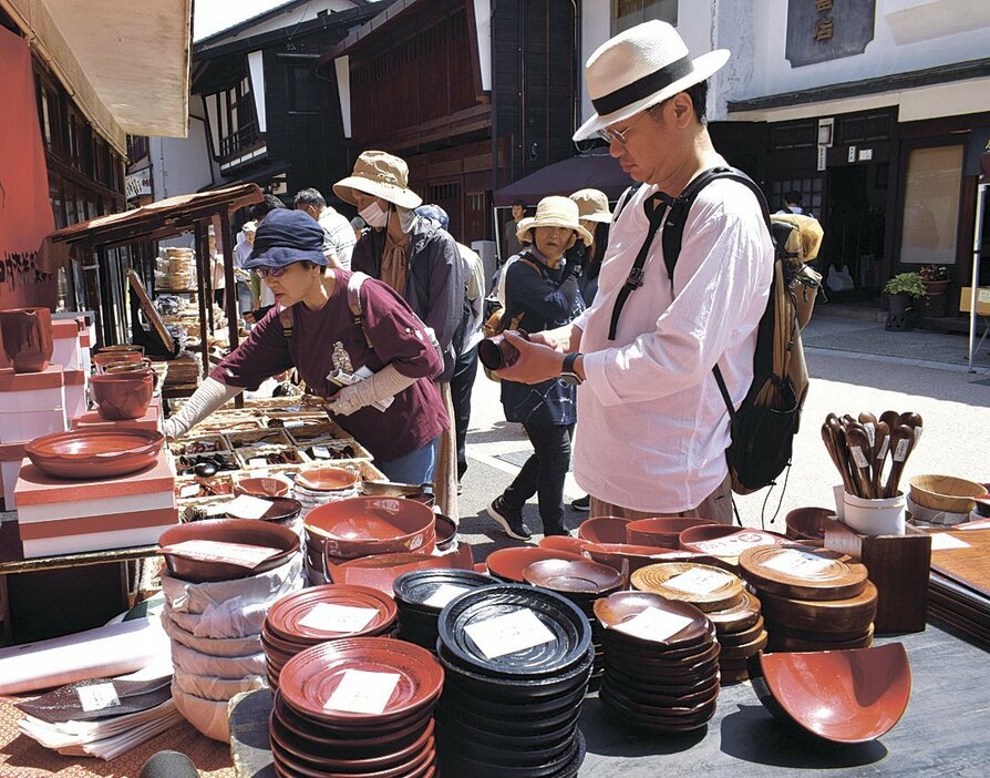 漆器市で、店先に並べられた製品を手に取る来場者（木曽平沢）