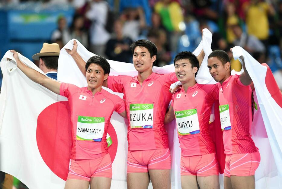 　リオ五輪４００メートルリレーで銀メダルを獲得し、日の丸を広げ肩を組む（左から）山県亮太、飯塚翔太、桐生祥秀、ケンブリッジ飛鳥＝１６年８月