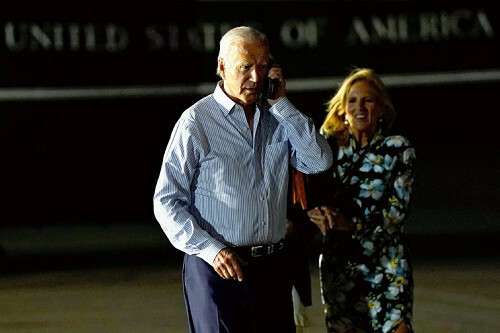 空軍基地に向かう途中、通話するバイデン大統領（右はジル夫人）（２９日）＝ロイター