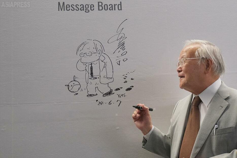 展覧会場のメッセージボードに記念のイラストを描く安彦良和氏。「描く人、安彦良和」9月1日まで兵庫県立美術館にて開催。（撮影：玉本英子）