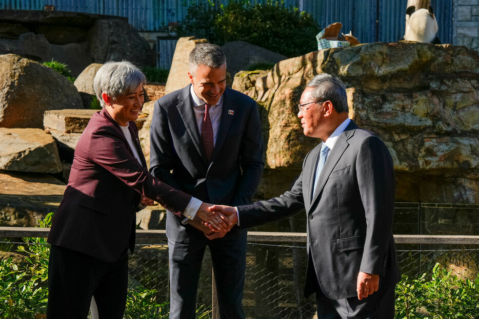 １６日、オーストラリア南部アデレードの動物園でウォン外相（左）と握手を交わす中国の李強首相（右）。