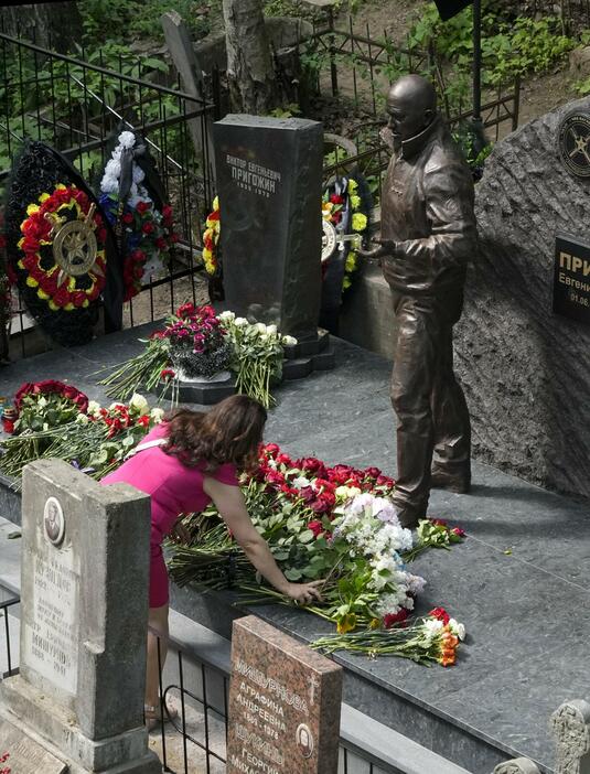 1日、ロシア・サンクトペテルブルクのプリゴジン氏の墓地で、花を手向ける女性（AP＝共同）