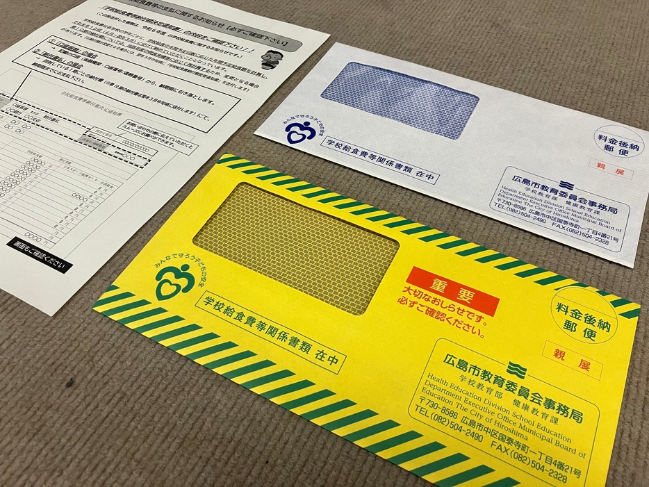 広島市教委が全世帯に配る給食費の支払いに関するお知らせと封筒。昨年度までの白色から、本年度は黄色に変え「重要」の文字を入れた