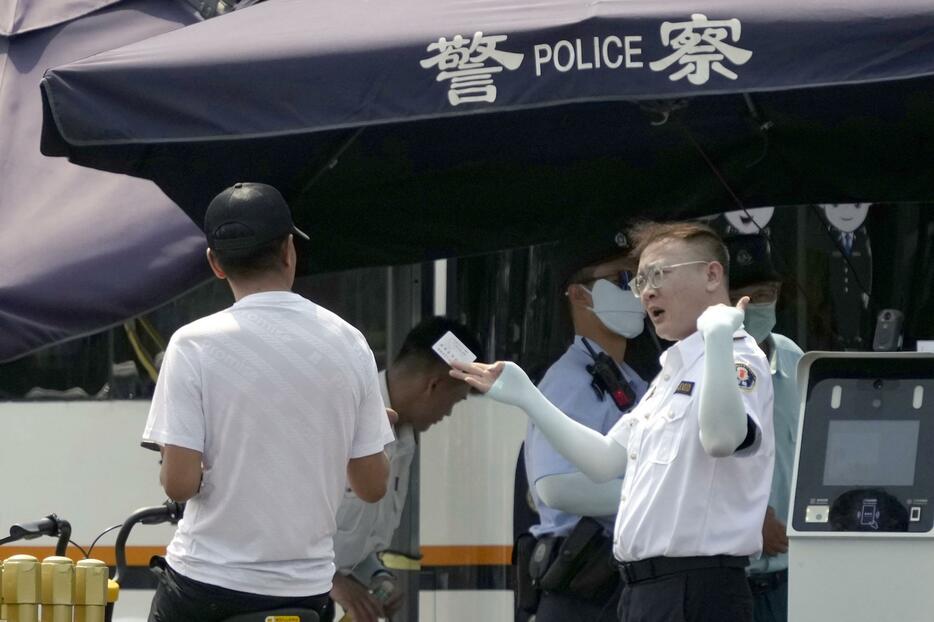 路上で通行人の身分証をチェックする警察官（右）＝6月、北京（共同）