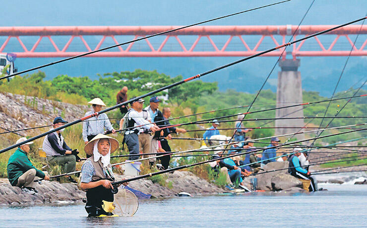 川面にさおを伸ばす釣り人たち=16日午前6時半ごろ、高岡市上麻生の庄川右岸