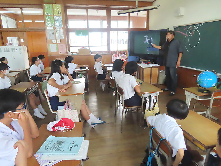 名瀬小での環境学習で講師を務めた蔵満逸司さん（右）＝19日、鹿児島県奄美市名瀬（提供写真）