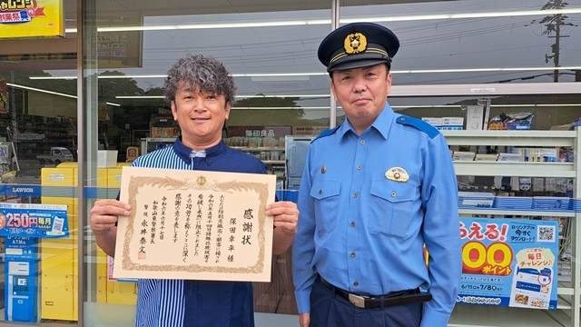 和歌山東署の永井署長（右）から感謝状を受け取る保田店長（左）