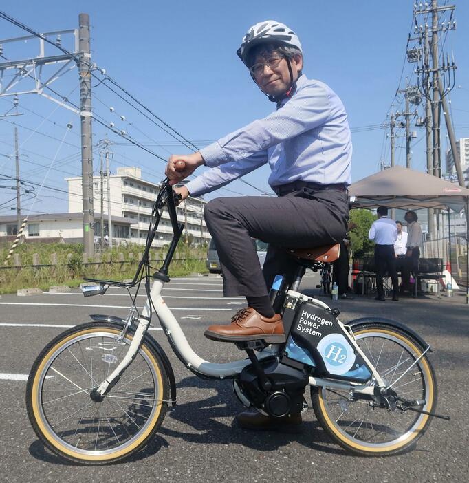 水素を燃料にするアシスト自転車に試乗するトヨタ紡織の社員＝14日午後、愛知県刈谷市
