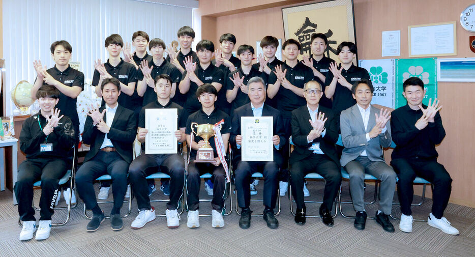 仙台大の高橋学長（前列左から５人目）に優勝を報告した男子バレーボール部の選手、スタッフら