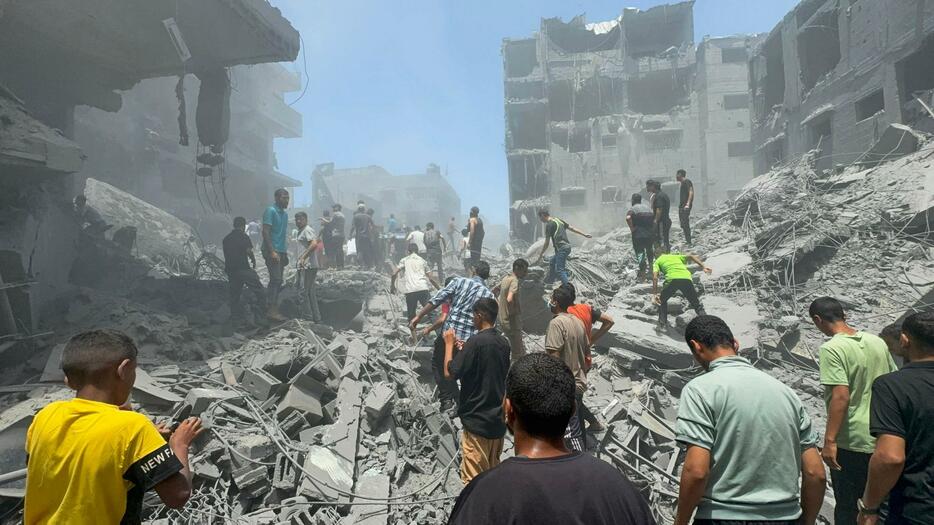 22日、パレスチナ自治区ガザ北部ガザ市で、イスラエルの攻撃後に救助活動をする人たち（ロイター＝共同）