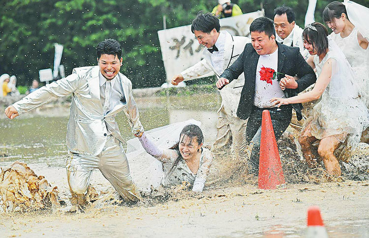 挙式後、手をつないで田んぼを走る夫婦（群馬県高崎市で）