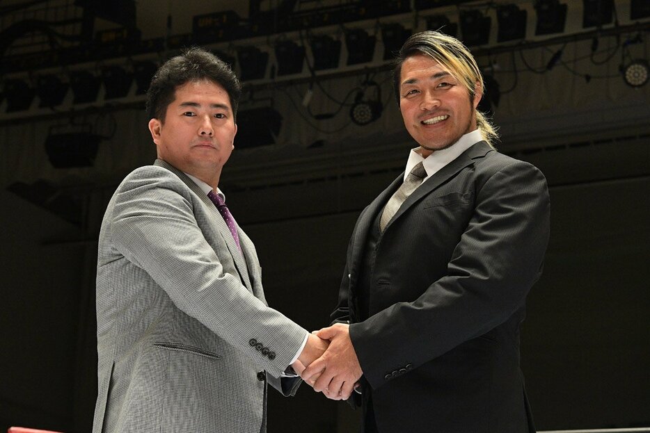 握手を交わす岡田太郎社長（左）と棚橋弘至