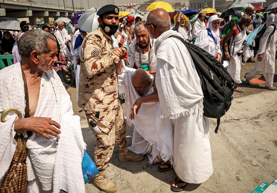 サウジアラビア当局は２３日、世界各地のイスラム教徒が西部の聖地メッカを訪れる大巡礼（ハッジ）で、巡礼者の死者数が１３００人を超えたと発表。写真は猛暑で体調を崩した巡礼者を介助する警察官ら＝１６日撮影
