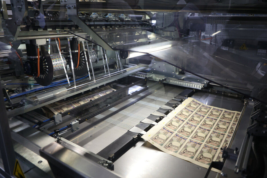 報道陣に公開された新紙幣のホログラム貼付工程＝１９日午後、東京都北区