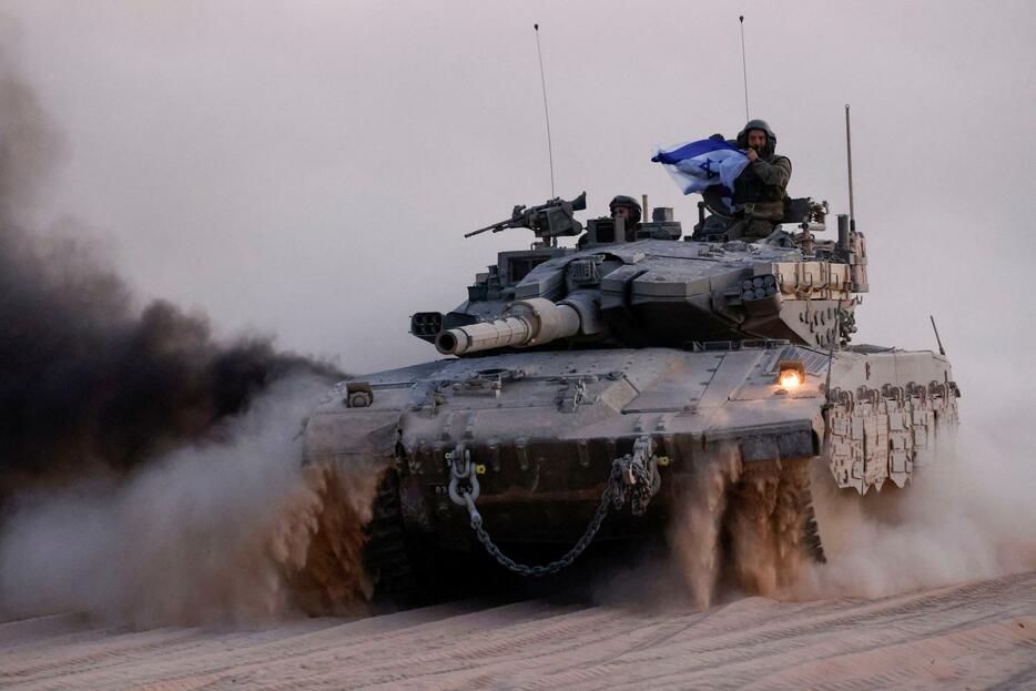 ガザ地区との境界に近いイスラエルを走行するイスラエル軍の戦車＝13日（ロイター＝共同）