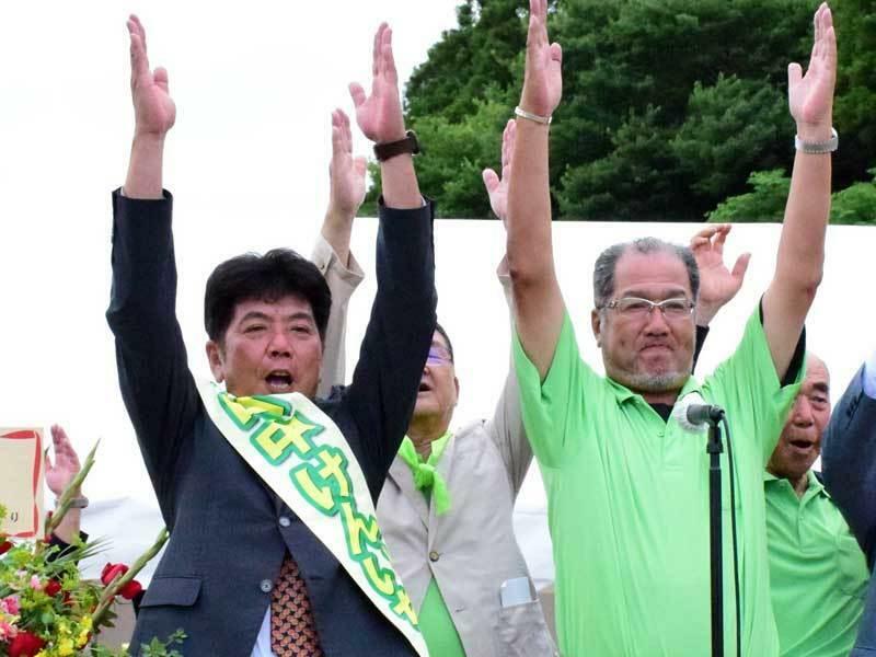 支援者と万歳して再選を喜ぶ田中氏（前列左）＝25日午後6時ごろ、睦沢町上市場